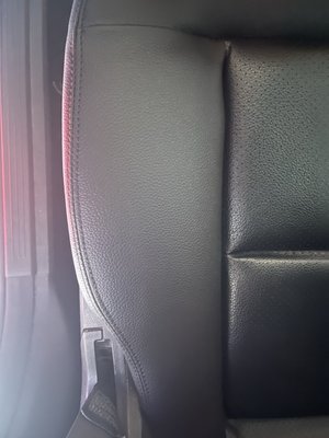 Close view of a black leather replacement seat panel and its stitching