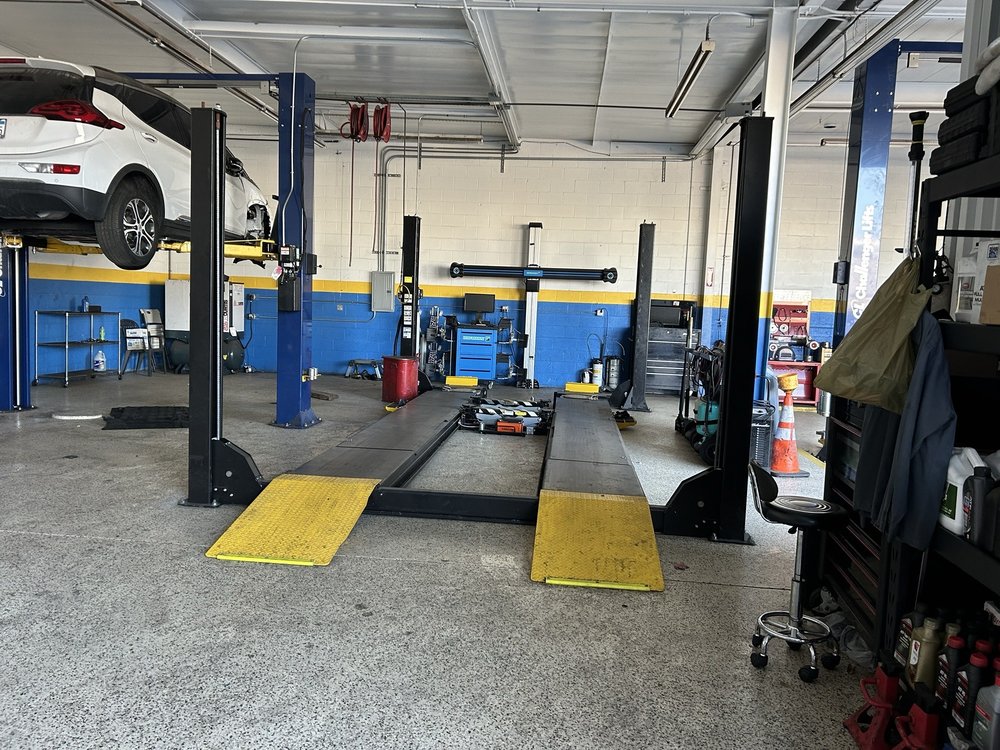 LJ Automotive wheel alignment bay with yellow ramps and blue lifts