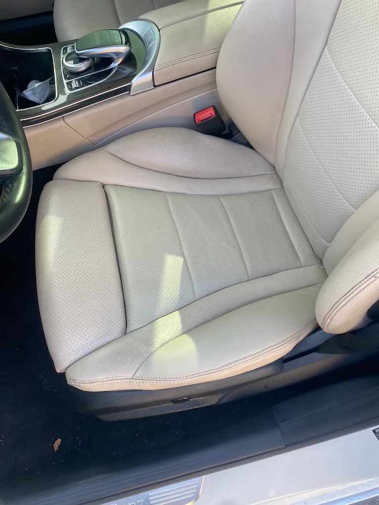 Beige perforated leather vehicle seat and center console